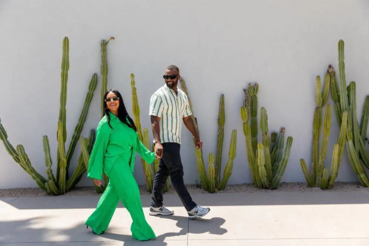 couple holding hands in front of cactus at Andaz Scottsdale romantic resort in Arizona